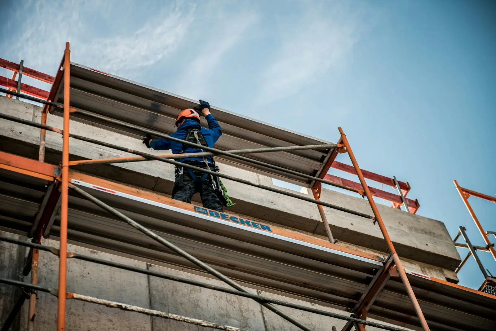 A scaffolder at work on a lift behind guardrails