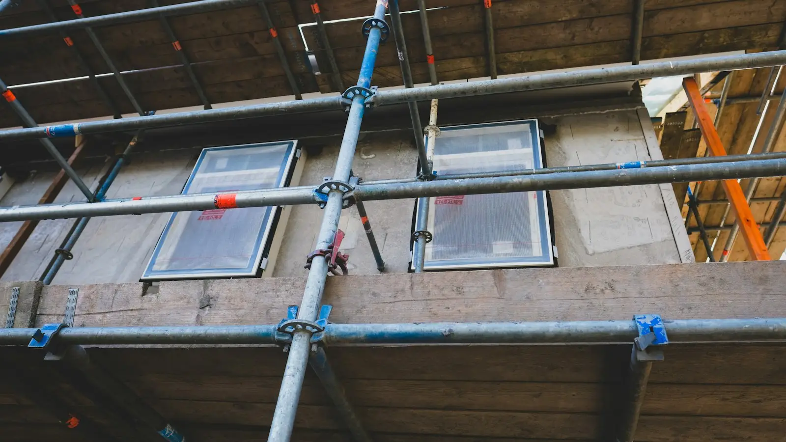 Tube and fitting scaffold with timber boards against a house wall